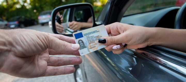 Driver handing over her US drivers license in Mexico. Cheap Mexican insurance.