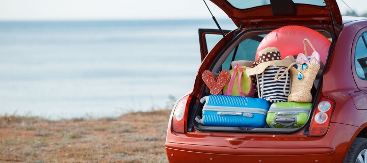 Suitcases and bags in trunk of car ready to depart for Mexico. Cheap Mexican Insurance.