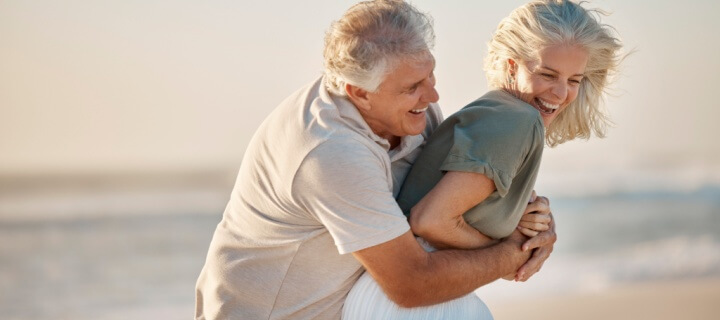 Senior couple, Winter Texans, snowbirds play on the beach in Mexico.