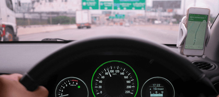 Driver's point of view from inside a car showing the dashboard and steering wheel while driving on a sunny Mexican highway. Best Mexico insurance