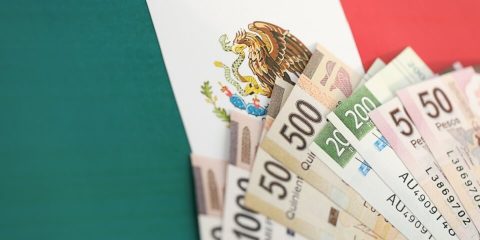 Billetes de pesos mexicanos sobre bandera de Mexico. Aseguranza para Mexico.