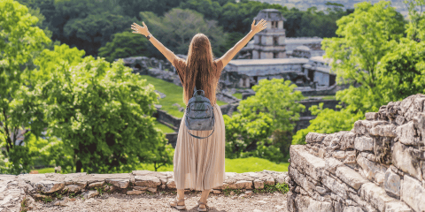 Mujer turista explorando las zona arqueologica de Palenque Chiapas. Seguro de auto para Mexico.