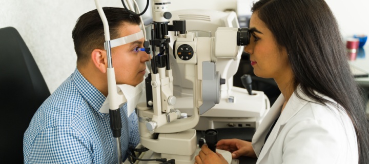 Ophthalmologist examining a male patient's eyes. Cheap Mexican Insurance. 