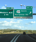 Letreros de autopista cerca de la frontera entre Estados Unidos y México, indicando las salidas hacia Western Ave y Mariposa Road, la ruta recomendada para viajar al sur de Nogales sin pasar por trafico. El mejor seguro de auto para Mexico.