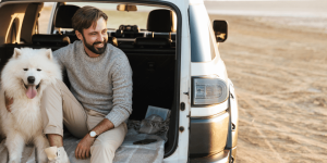 Hombre con su perro disfrutando de la playa en su SUV. Seguro de auto mexicano para USA.