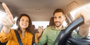 Familia manejando en Mexico. Mujer apuntando hacia la direccion. Aseguraza para Mexico.