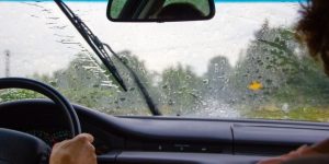 Pareja manejando mientras llueve intensamente. Seguro de Auto para Mexico