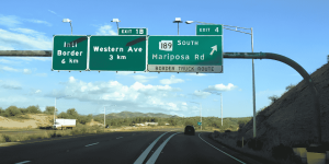 Letreros de autopista cerca de la frontera entre Estados Unidos y México, indicando las salidas hacia Western Ave y Mariposa Road, la ruta recomendada para viajar al sur de Nogales sin pasar por trafico. El mejor seguro de auto para Mexico.