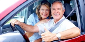 Happy Couple in the car ready to drive to Mexico. Long Term Mexico Insurance policy.