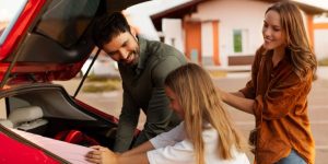 Family loading luggage in preparation for summer road trip. Mexico auto insurance